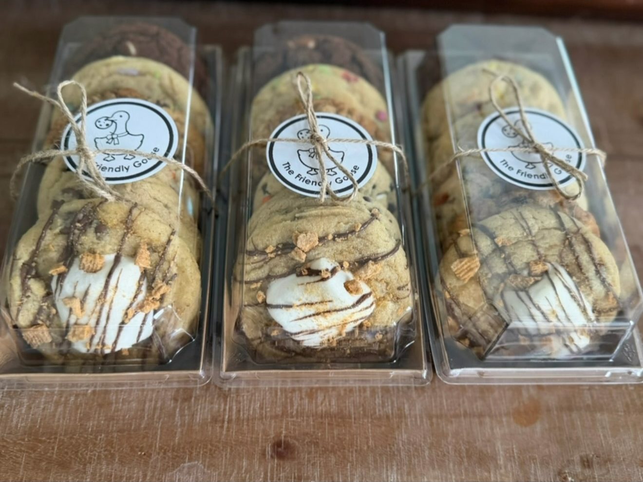 Three clear boxes of stacked Friendly Goose cookies tied with twine and labeled with the goose logo